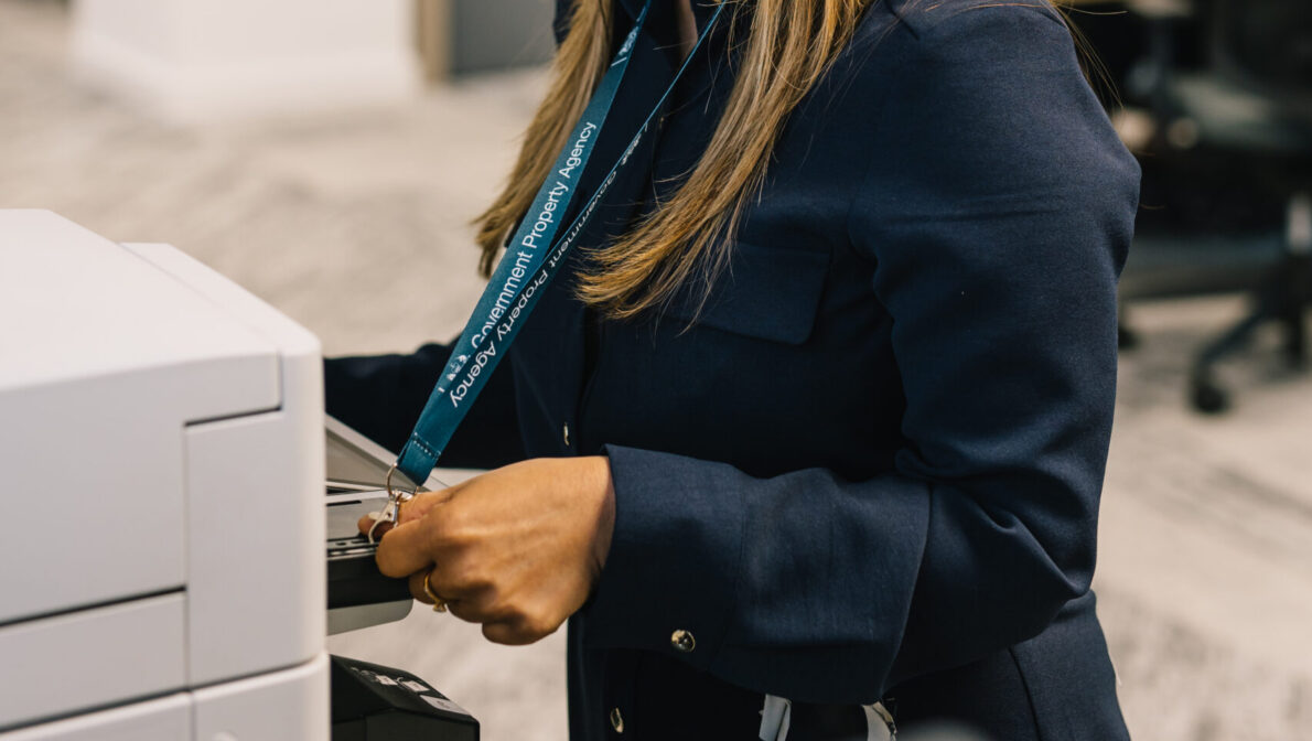 A female hand holds a GovPass against a log in unit