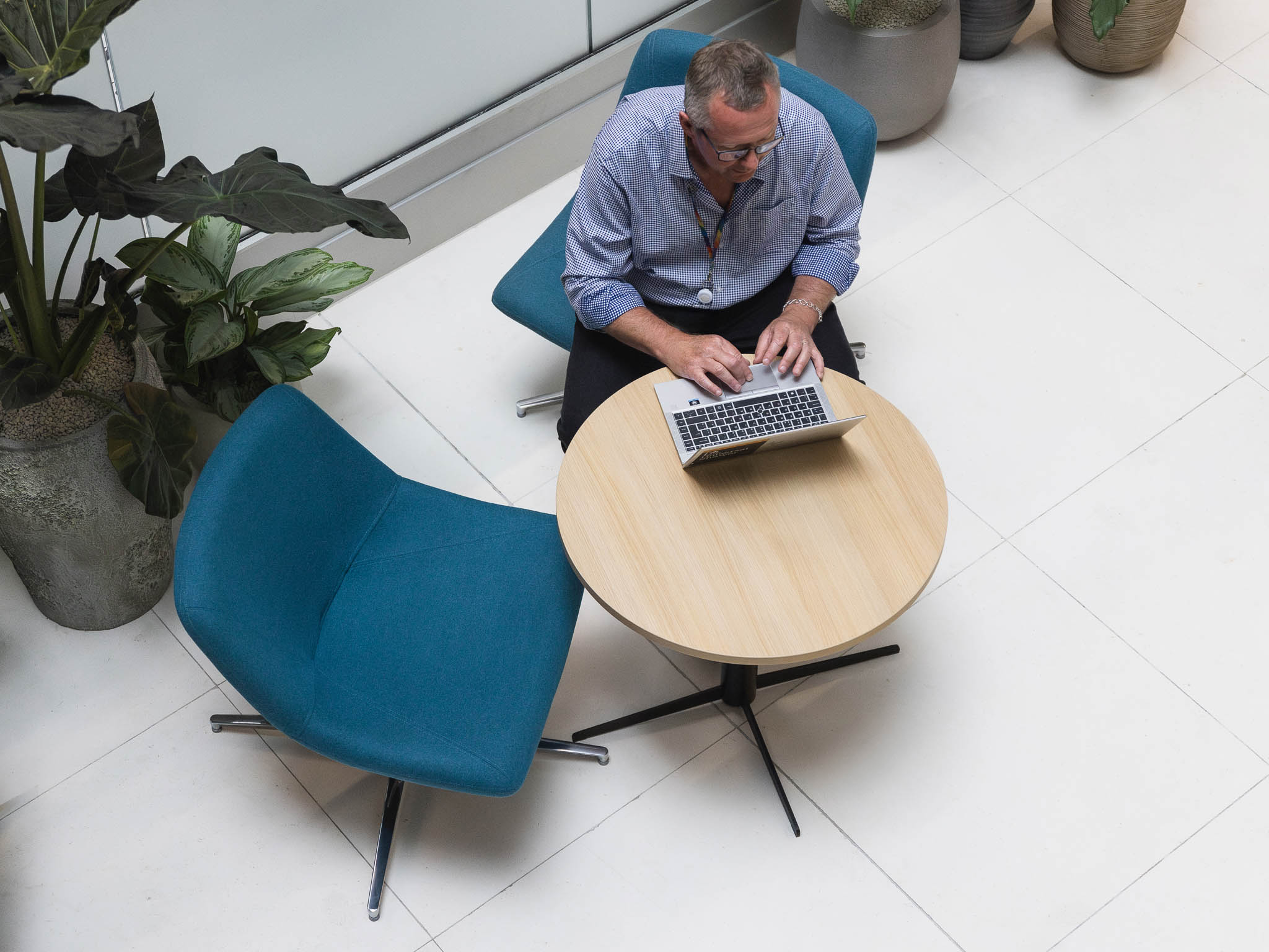 A man typing on a laptop at a cafe table