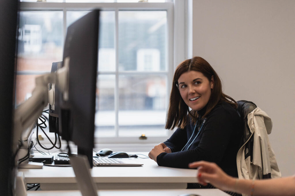 Colleague working at a desk smiling