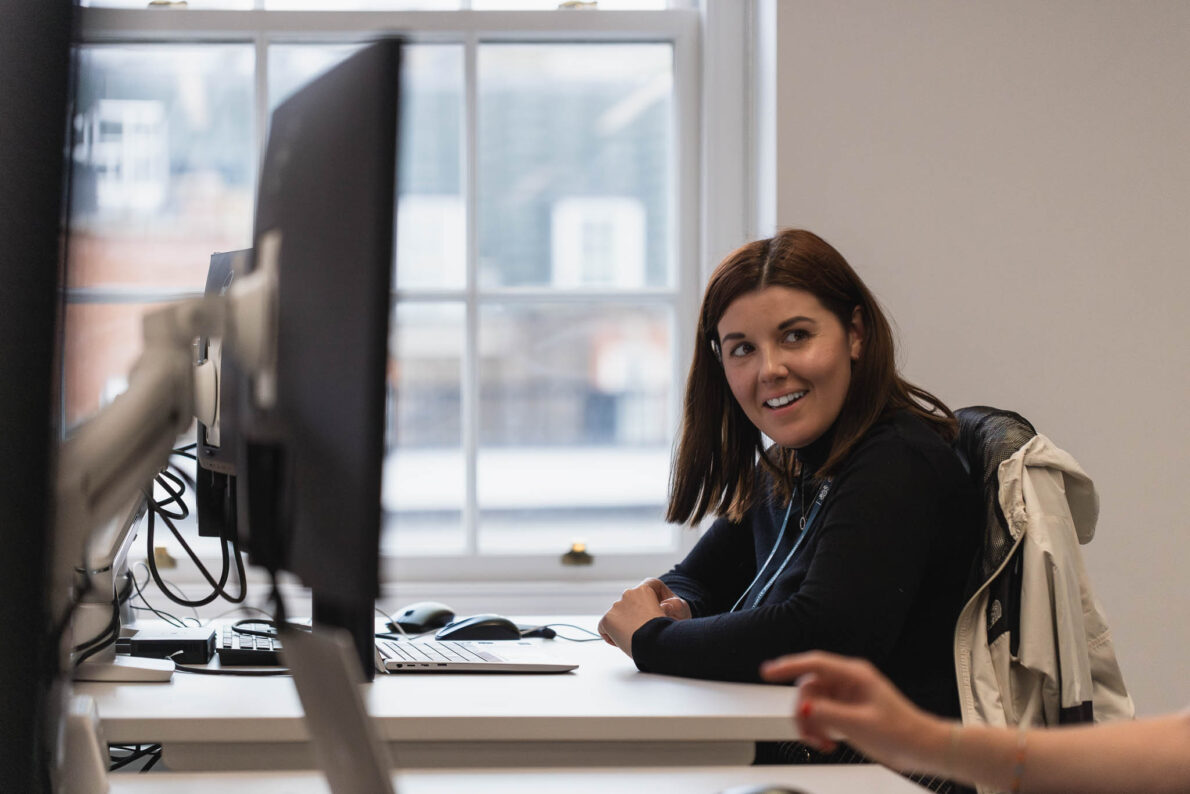 Colleague working at a desk smiling